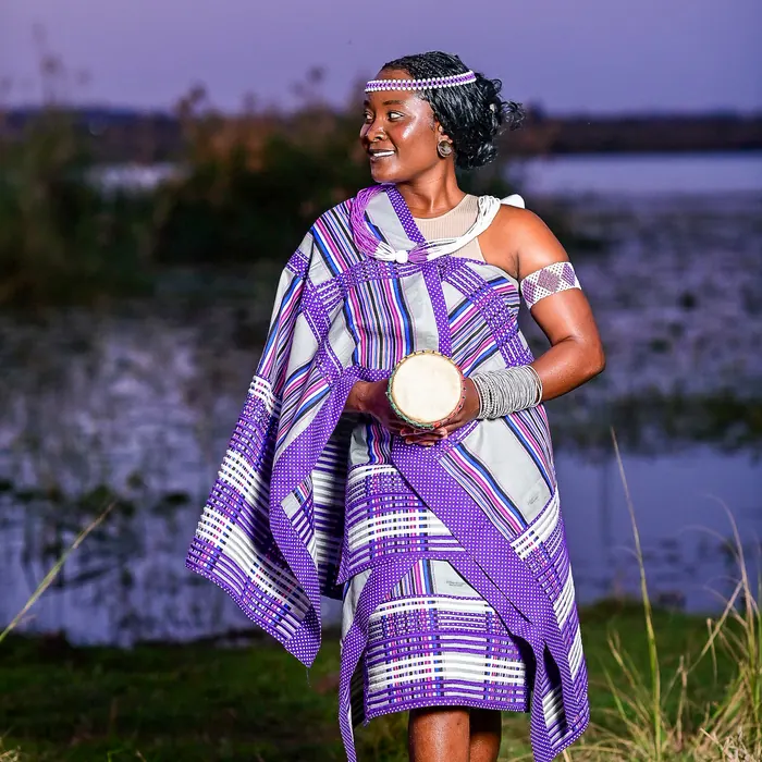 A woman in a purple minwenda by the water.