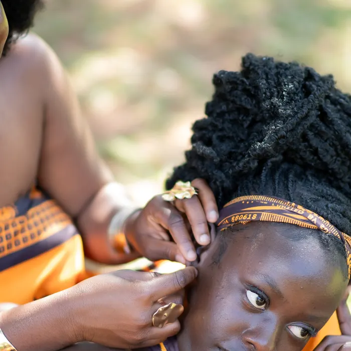 A close moment between two women in the shade.